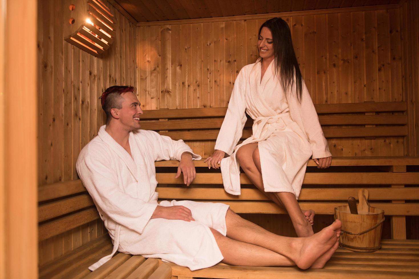 A couple relaxing together in a wooden sauna, enjoying warmth and wellness.