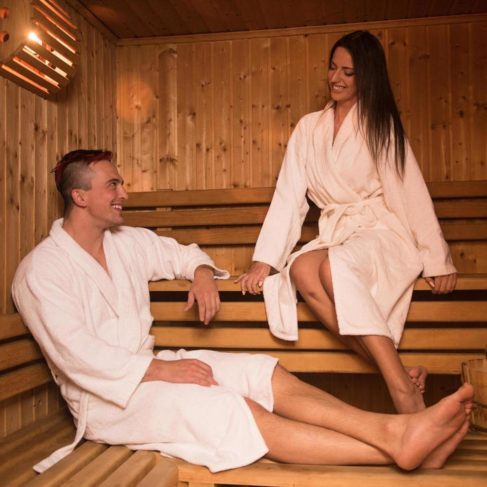 A couple relaxing together in a wooden sauna, enjoying warmth and wellness.