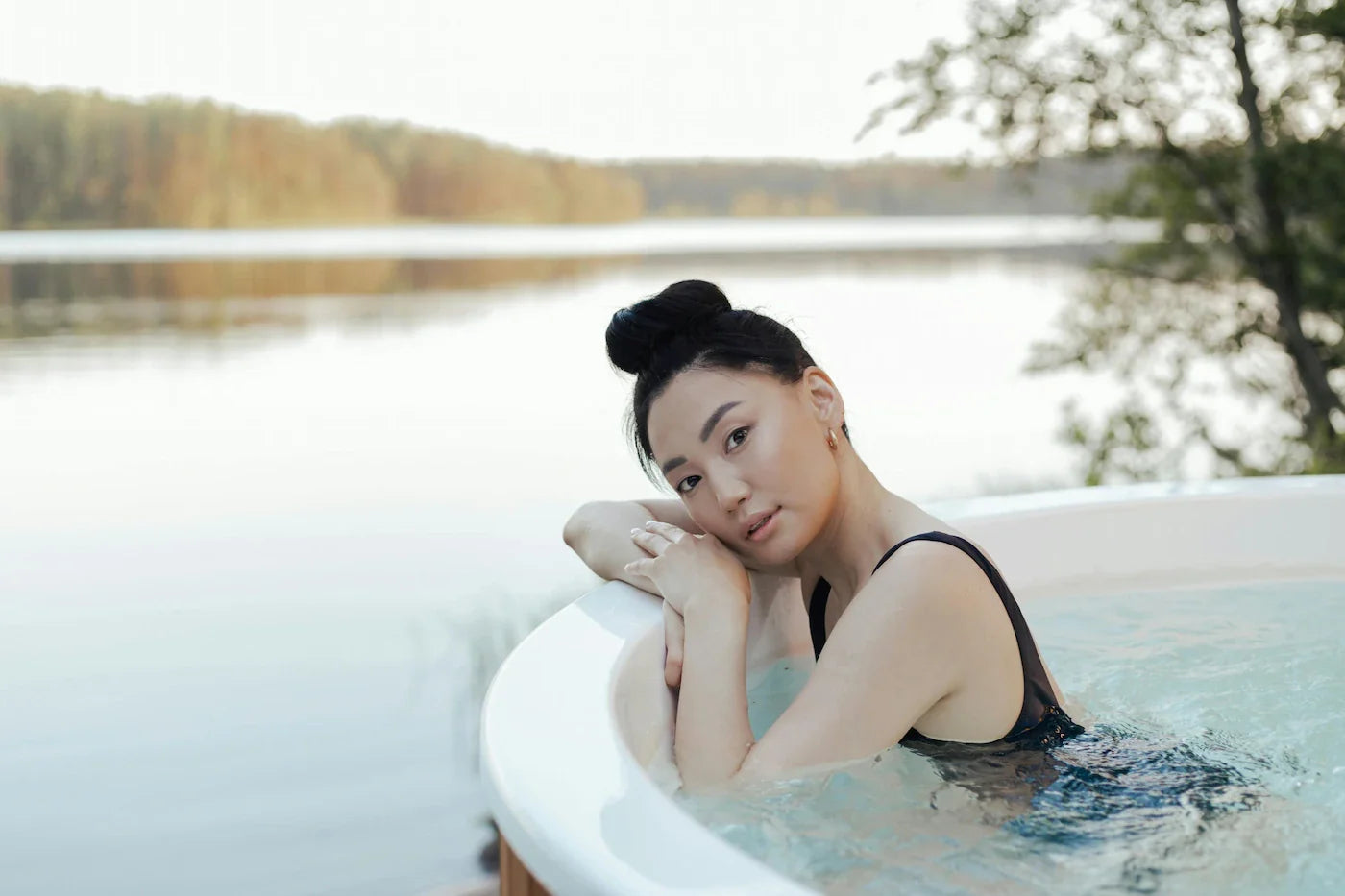 Woman in a luxury outdoor cold plunge surrounded by natural elements, highlighting the rejuvenating outdoor wellness lifestyle in Why You Need a Cold Plunge in Your Life.